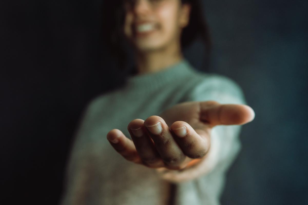 a person extends a hand to a patient who enters a methadone treatment for addiction