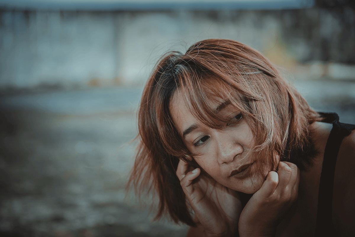 a woman sits outside looking sullen from benzo side effects