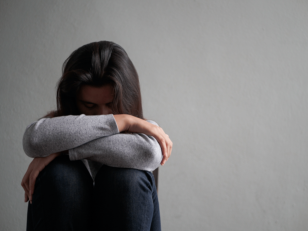 a person sits against a wall folded into their knees as they learn about crack vs cocaine