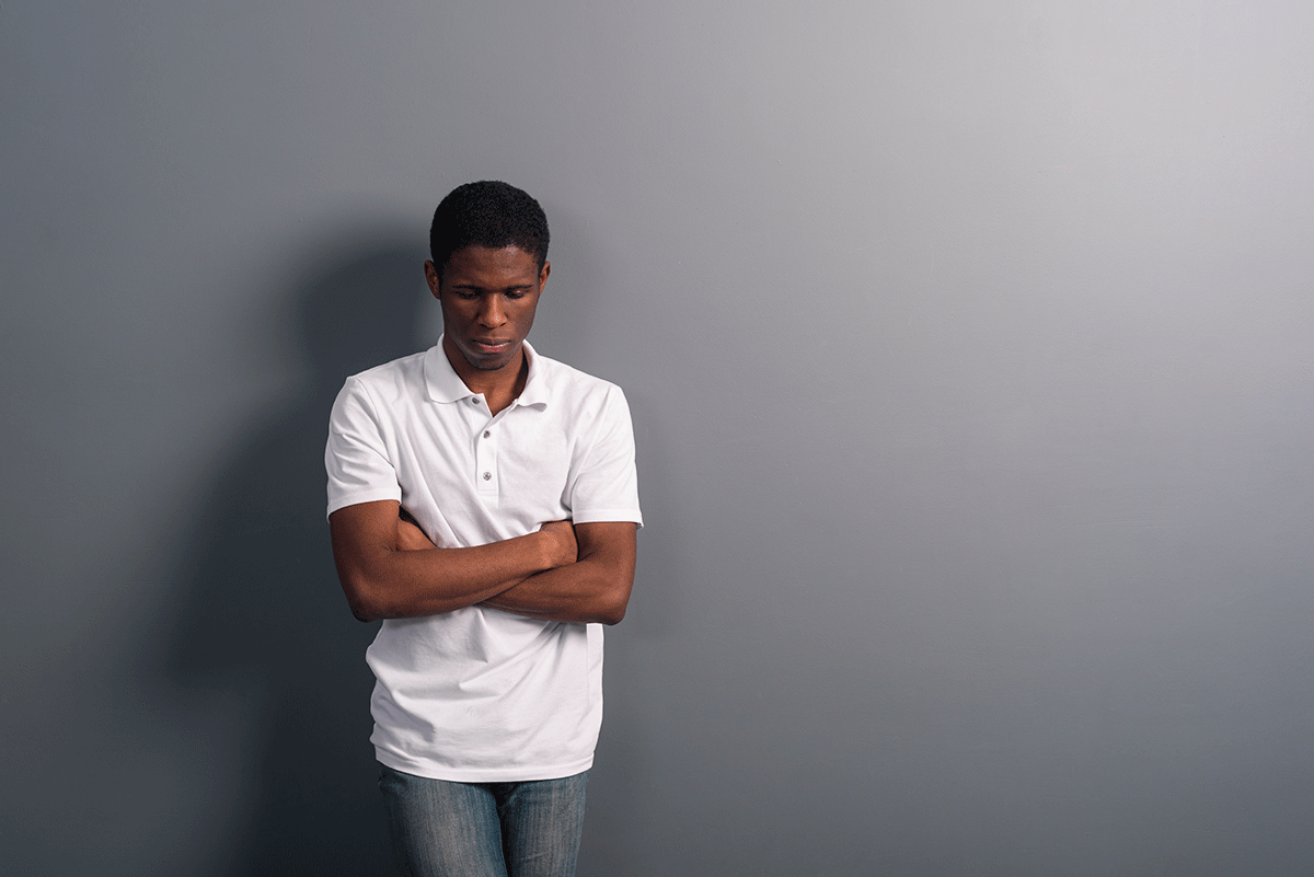 a person leans against a wall outside while experiencing high-functioning depression