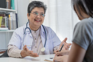 a doctor with short hair and glasses talks to a patient about outpatient program