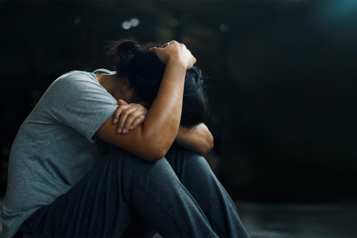 a person looks anxious by putting their head between their knees to show the effects of alcohol and anxiety