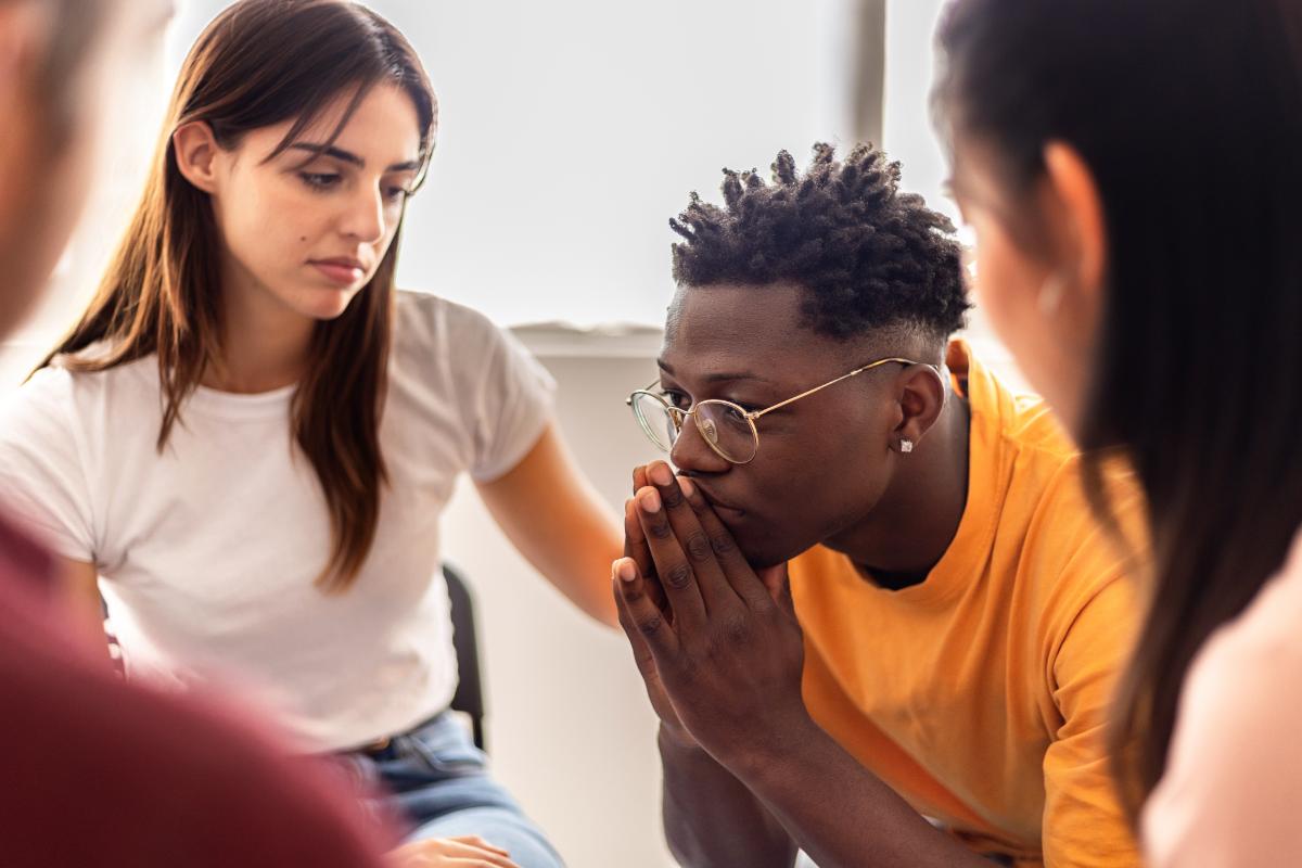 a group of people comfort someone during a drug and alcohol detox center in Massachusetts