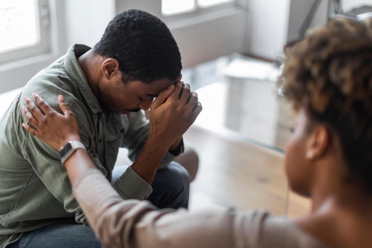 a person puts their head in their hands to show heroin dependence