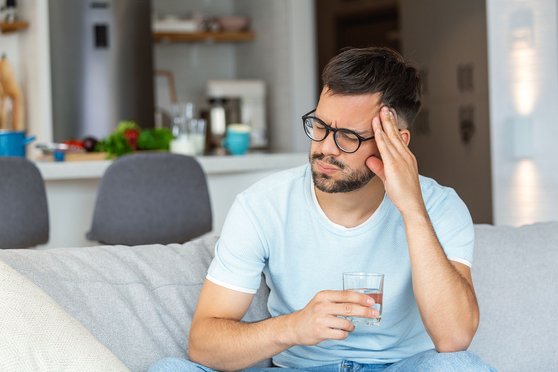 a person puts their hand on their temple while experiencing vivitrol side effects