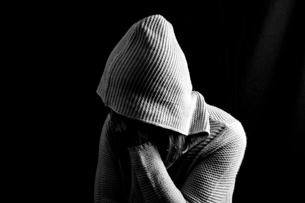 a person in a hoodie experiences heroin withdrawal symptoms