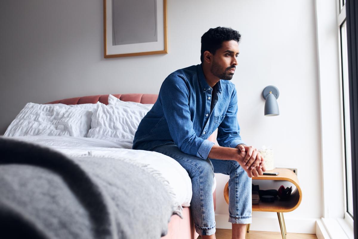 a person sits on the edge of their bed wondering about the stages of detox