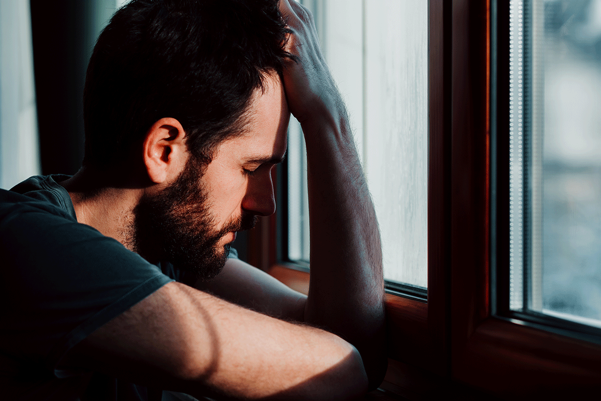 a person puts a hand on their forehead as they deal with alcoholic nose