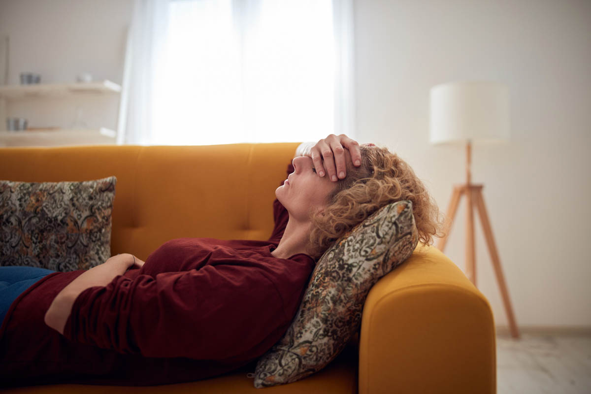 a person lays on a couch while experiencing oxycontin abuse