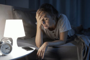 a person sits by a lamp in bed while experiencing methadone side effects