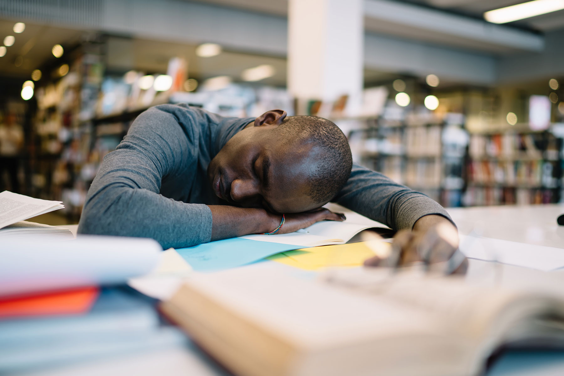 a person falls asleep on a desk to show sleep deprivation and mental health