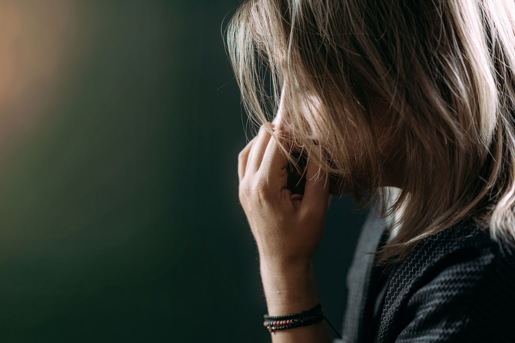 a person leans on their balled fist to show struggle with ptsd and addiction