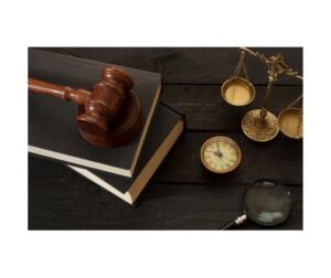 a judge's gavel on a podium with books and scales