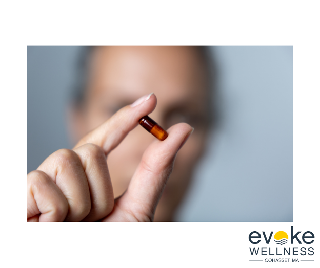 Woman holds an Ibuprofen pill